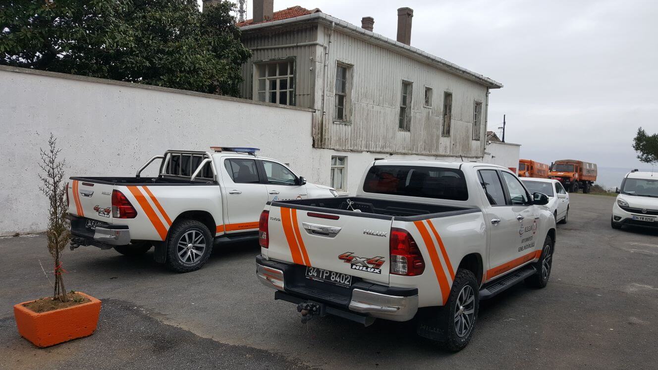 Çift araç giydirme örneği gösteren fotoğraf, iki beyaz pick-up yan yana park halinde.